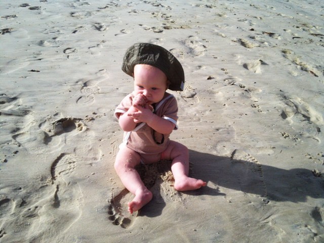 the baby eating sand